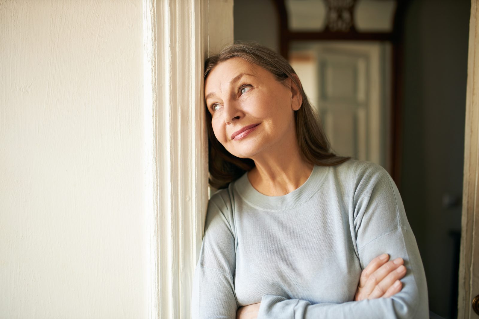 Woman by window looking thoughtful